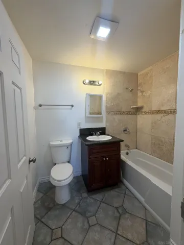 a bathroom with a granite countertop toilet a sink and bathtub