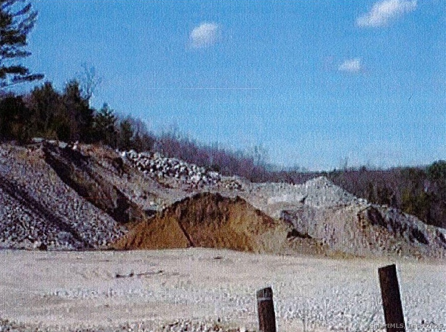 a view of a dry yard with wooden fence