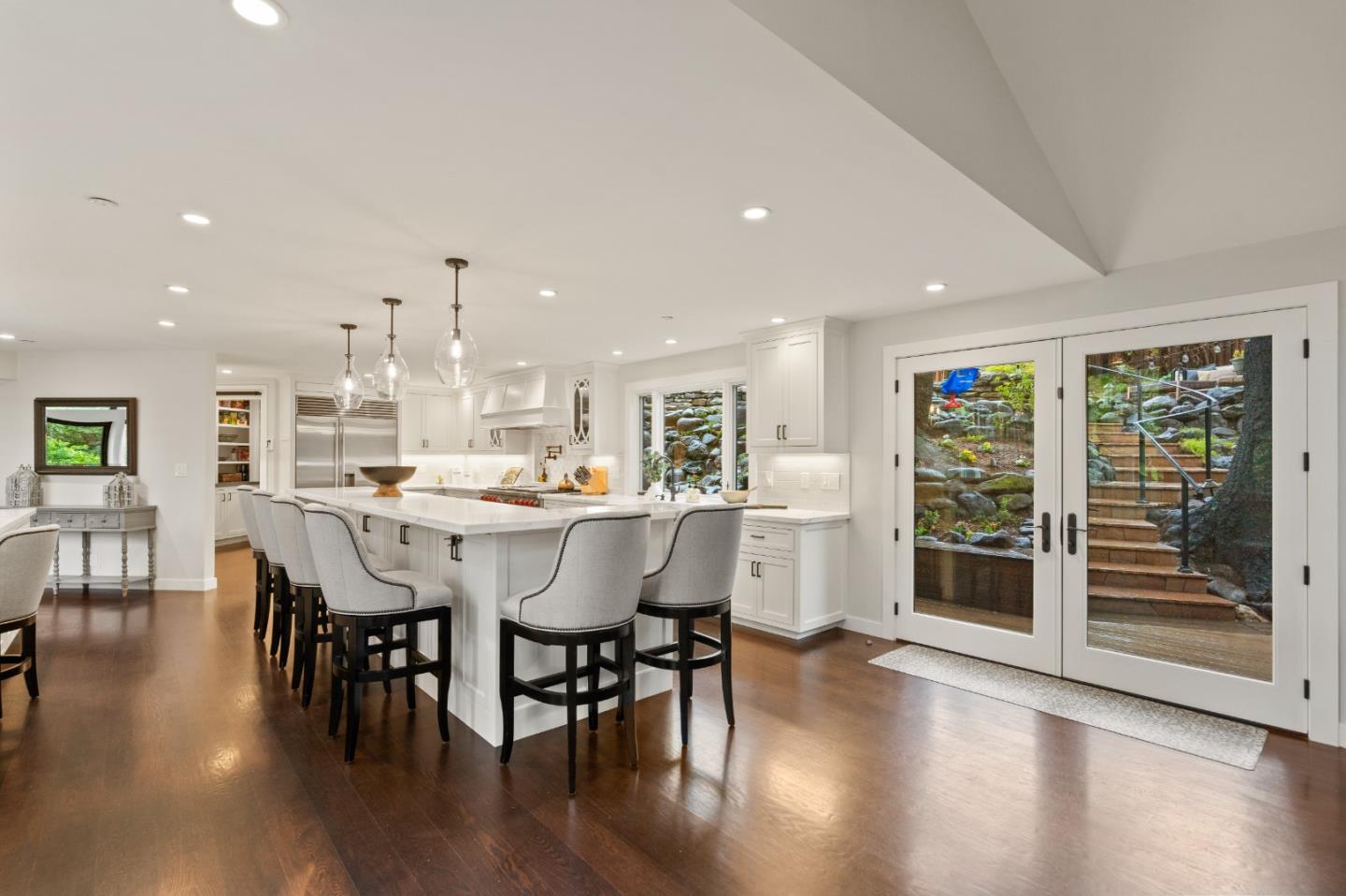 a dining room with stainless steel appliances wooden floors a table and chairs