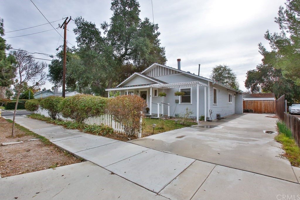 a front view of a house with a garden and trees