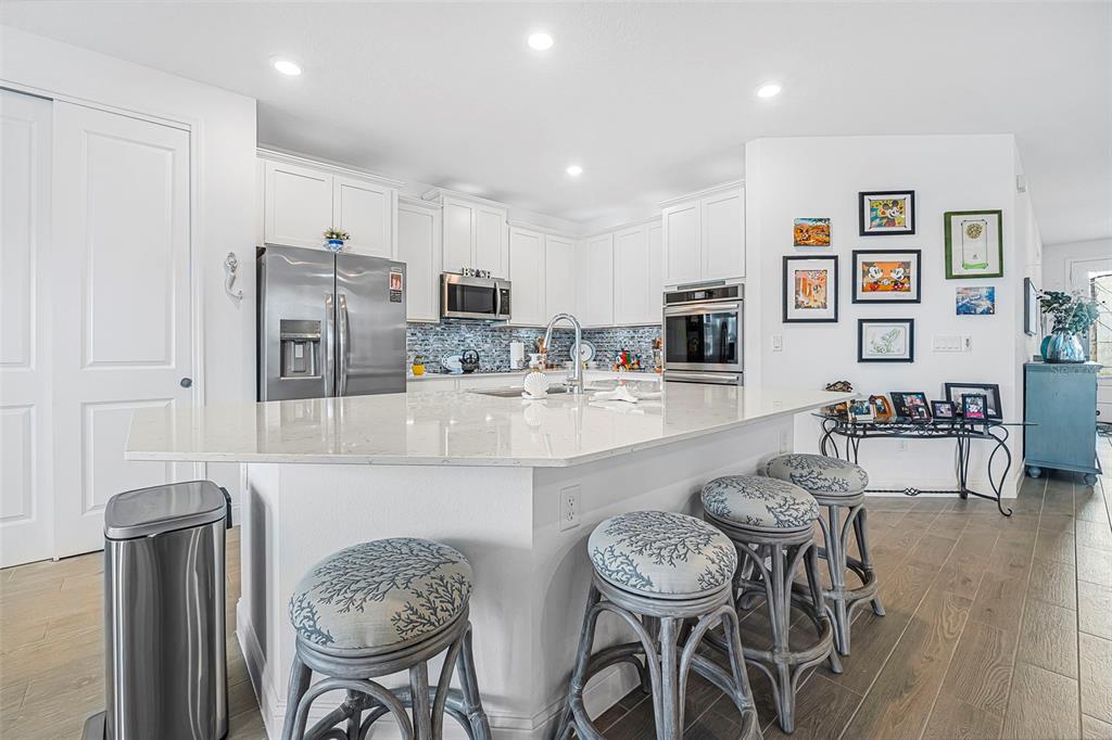 2128 Raglan Circle Ormond Beach, FL 32174 - Photo 12 of 55 a kitchen with stainless steel appliances kitchen island granite countertop a dining table and chairs