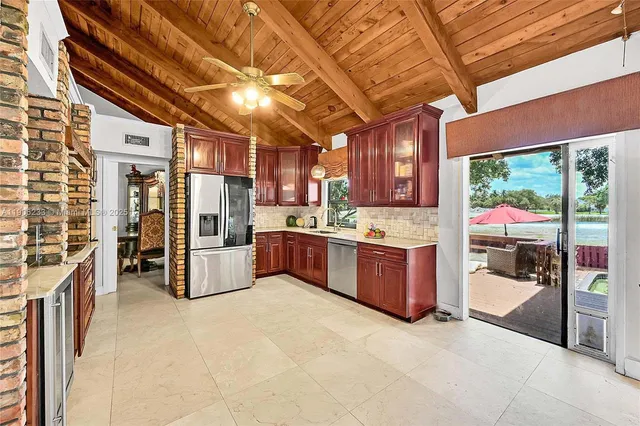 a large room with stainless steel appliances kitchen island granite countertop a large cabinets a sink and a counter top space