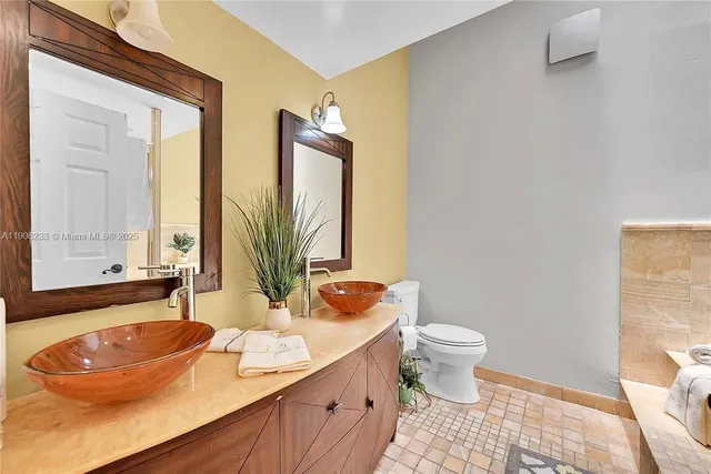 a bathroom with a sink a toilet and mirror