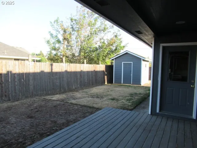 a view of backyard with small cabin and wooden fence