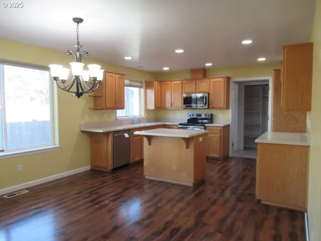 a kitchen with kitchen island granite countertop wooden floors and white cabinets