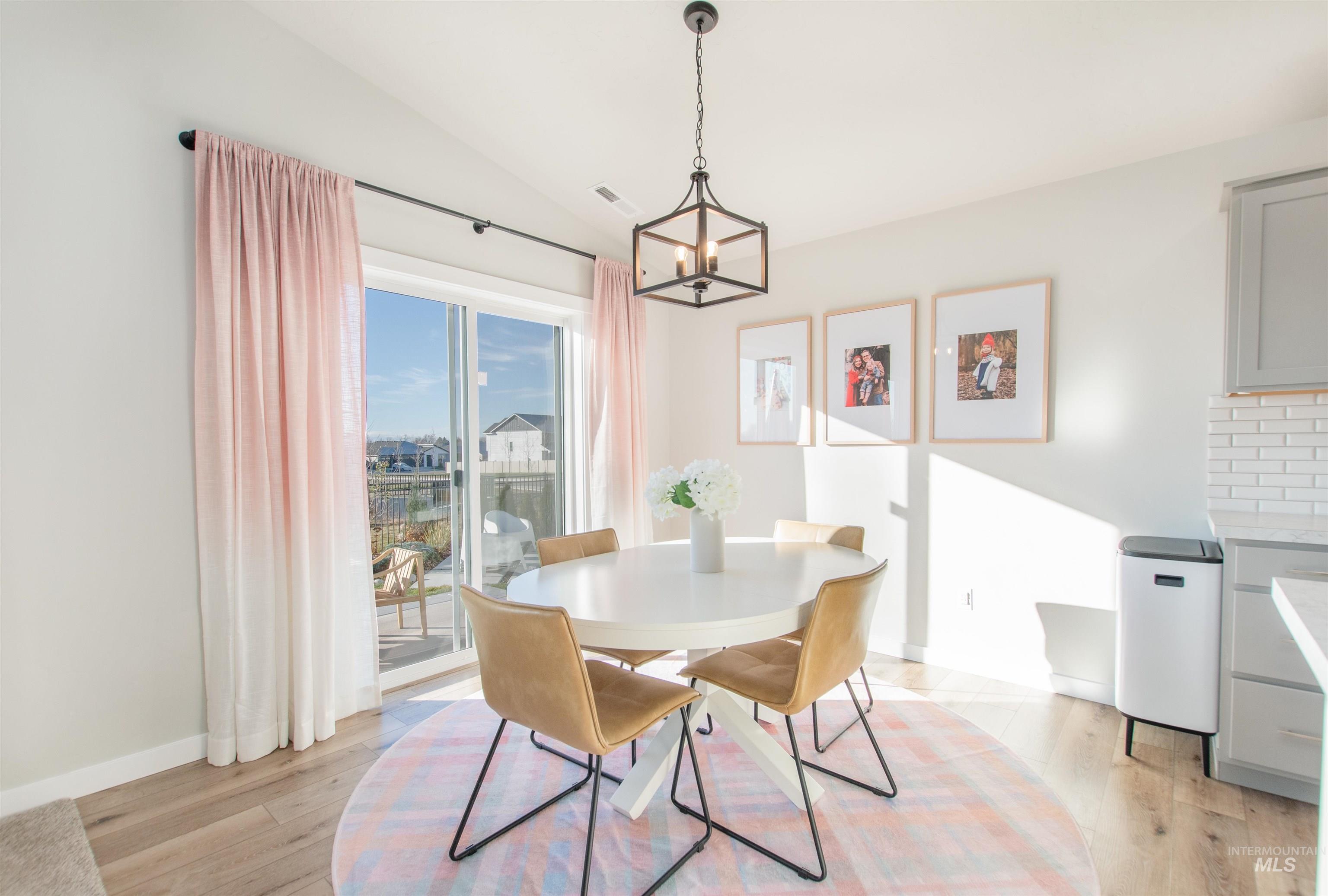 11289 West Langit Street Star, ID 83669 - Photo 11 of 33 Dining area featuring vaulted ceiling, light wood-style flooring, and a chandelier