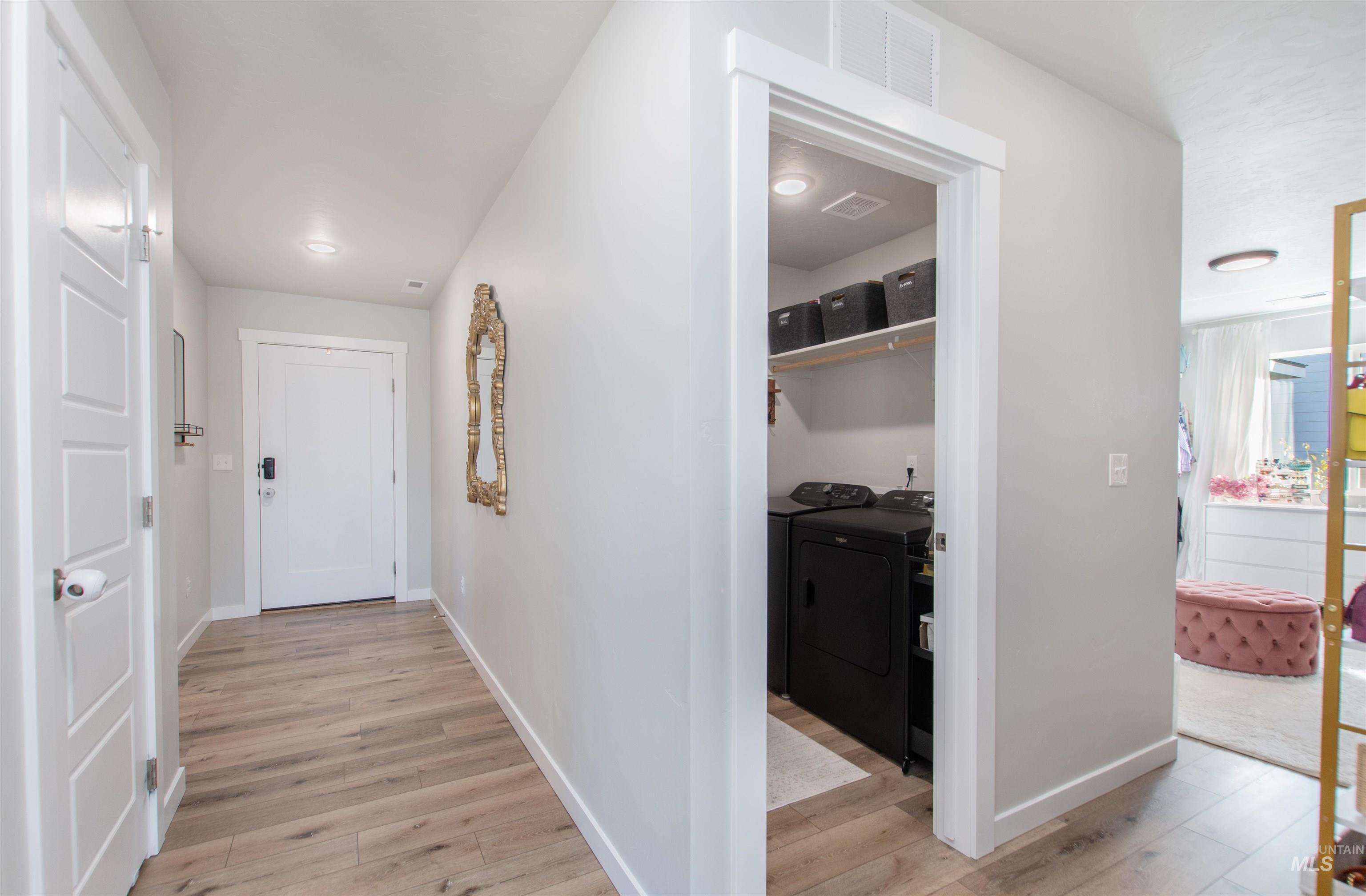 11289 West Langit Street Star, ID 83669 - Photo 22 of 33 Hallway featuring light wood finished floors and washing machine and dryer