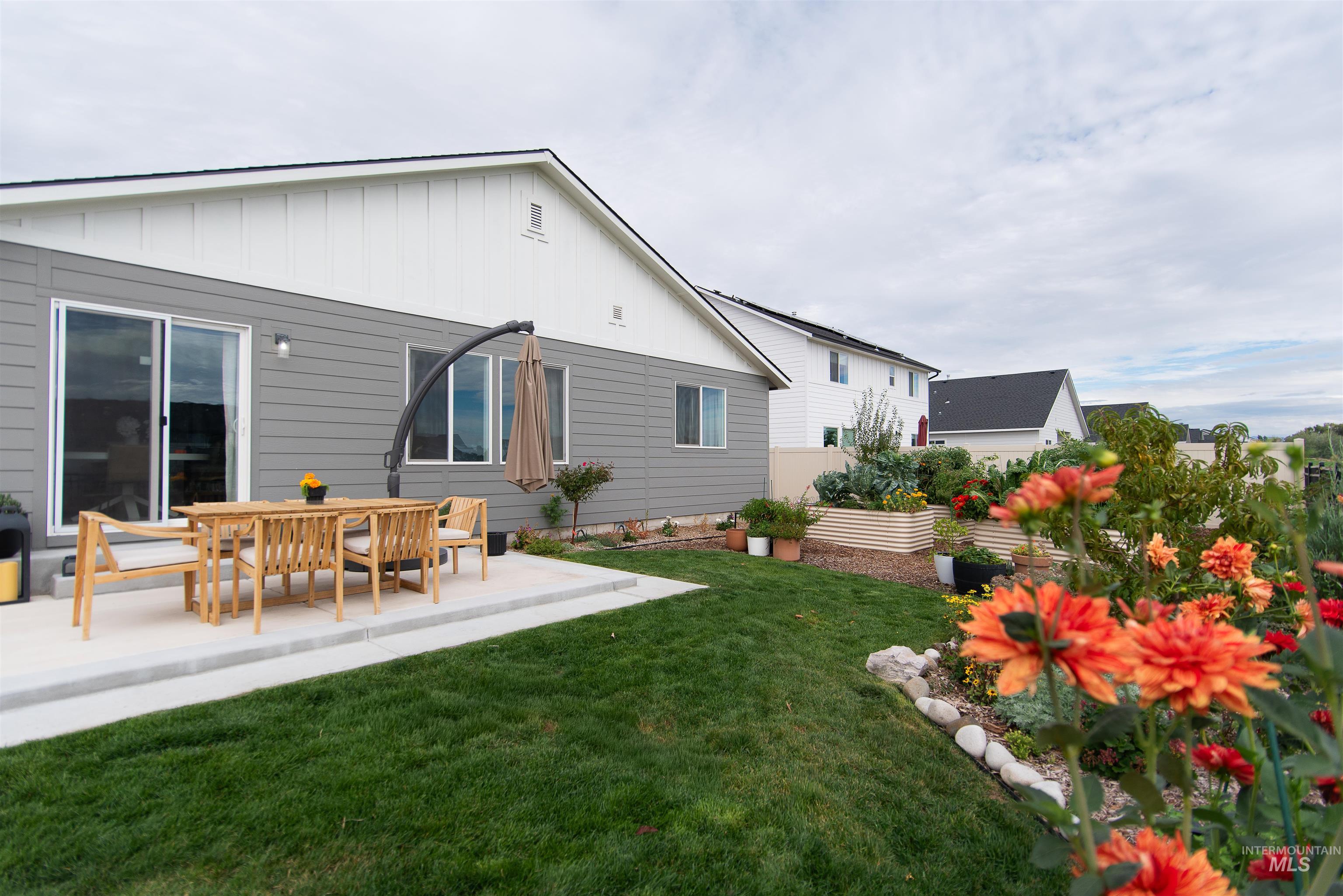 11289 West Langit Street Star, ID 83669 - Photo 4 of 33 Back of house featuring board and batten siding, a yard, and a patio