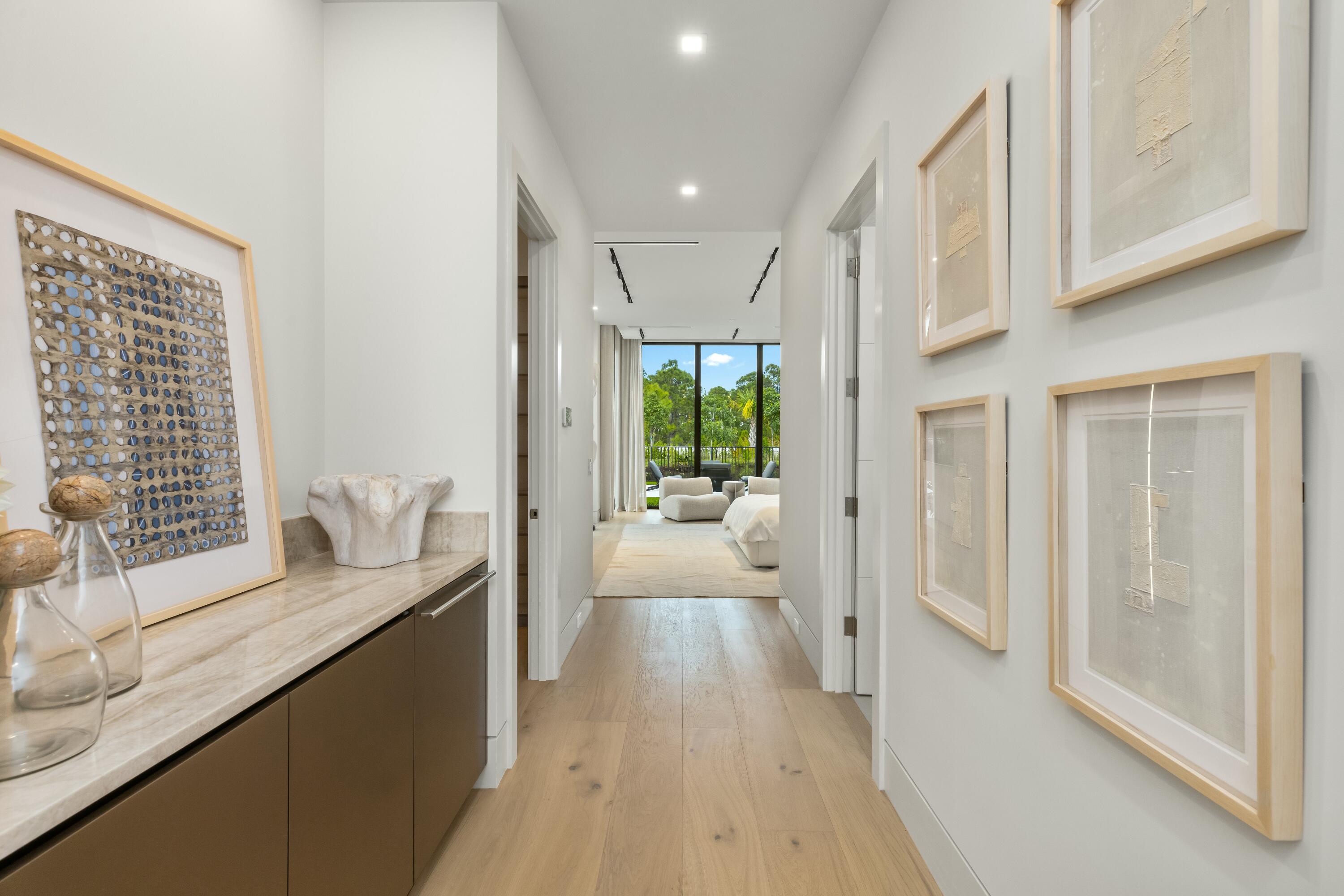 13089 Monte Rosa Court Palm Beach Gardens, FL 33412 - Photo 15 of 34 a view of a hallway with wooden floor and furniture