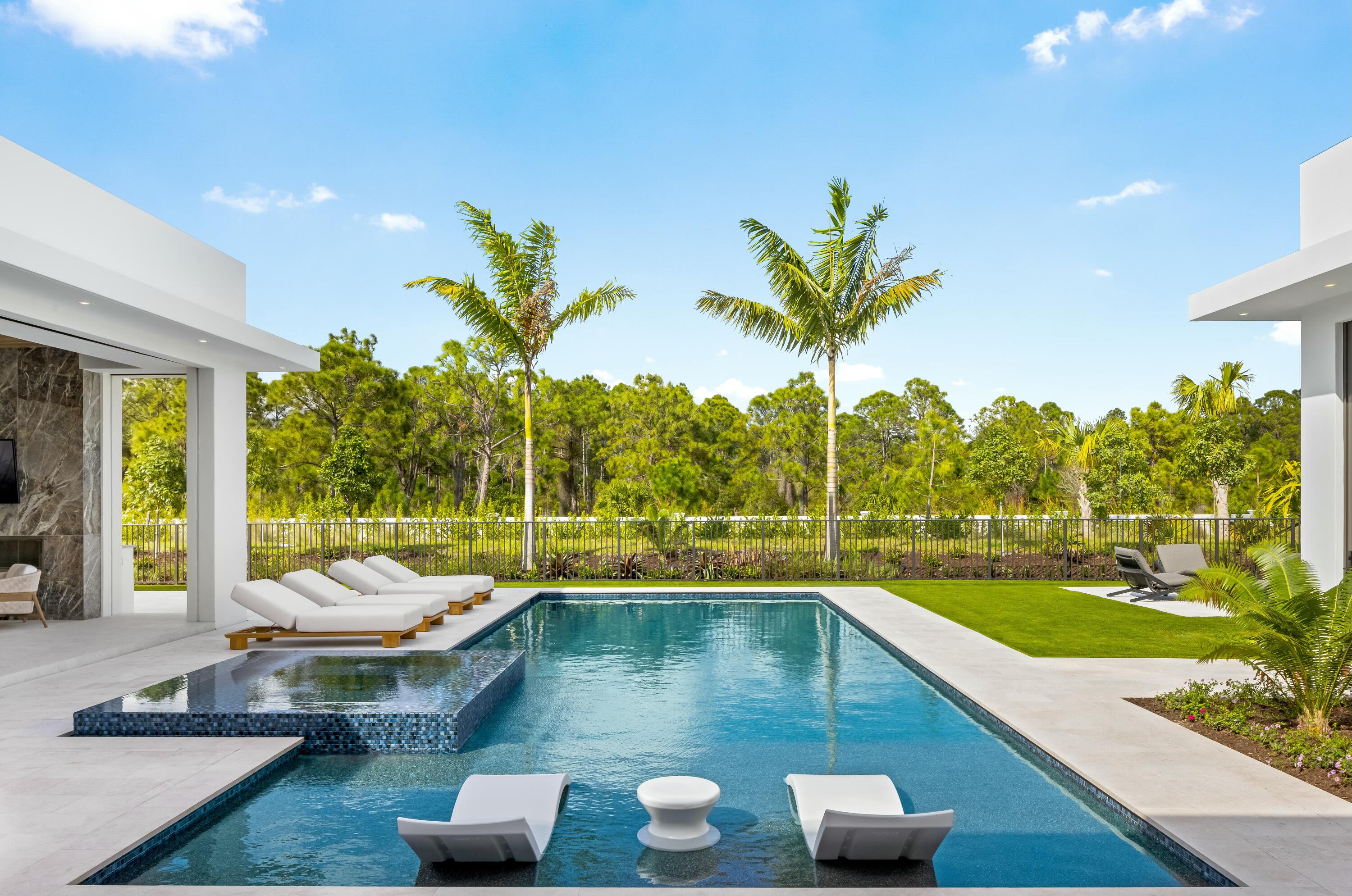 13089 Monte Rosa Court Palm Beach Gardens, FL 33412 - Photo 27 of 34 a view of a swimming pool with a lounge chair