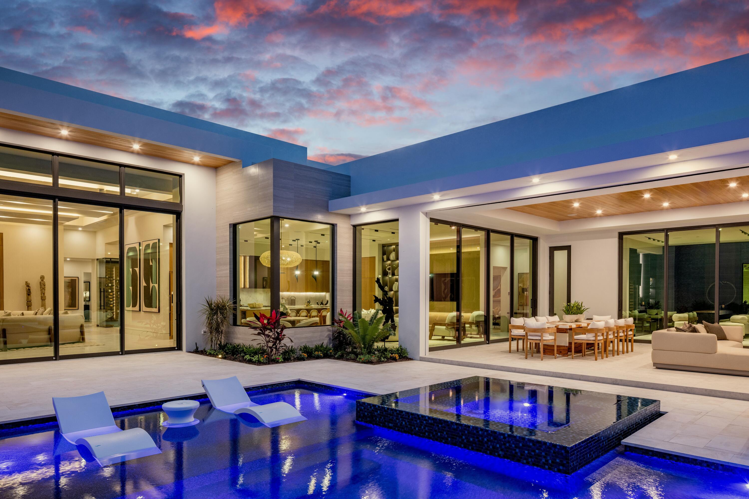 13089 Monte Rosa Court Palm Beach Gardens, FL 33412 - Photo 33 of 34 a living room with furniture a large window and potted plants