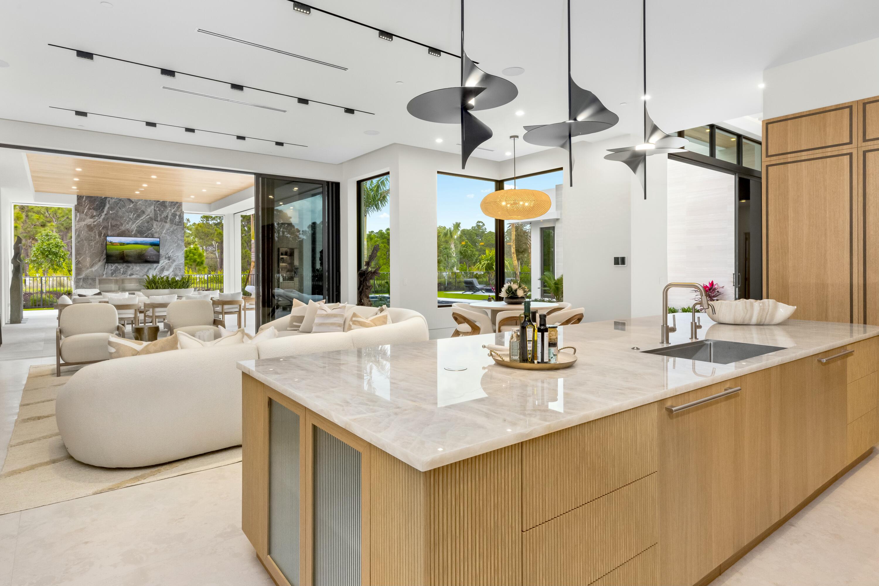13089 Monte Rosa Court Palm Beach Gardens, FL 33412 - Photo 7 of 34 a kitchen with sink cabinets and living room view