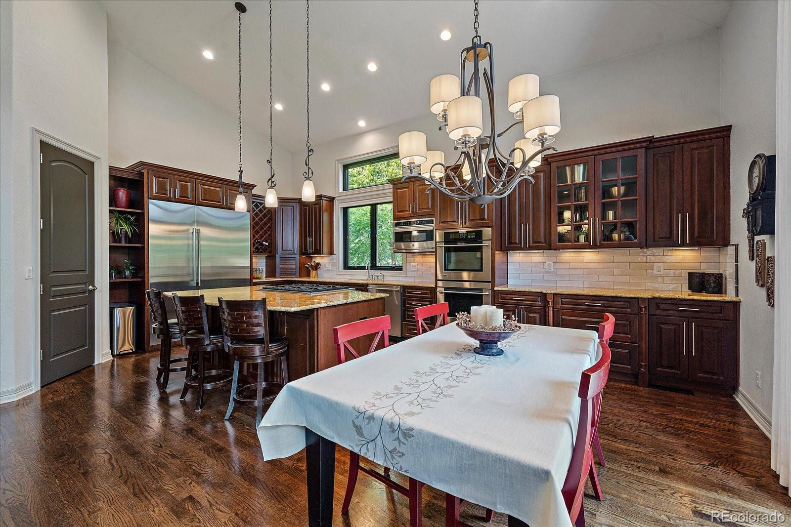 20132 East Shady Ridge Road Parker, CO 80134 - Photo 12 of 36 a kitchen with a dining table chairs and wooden floor