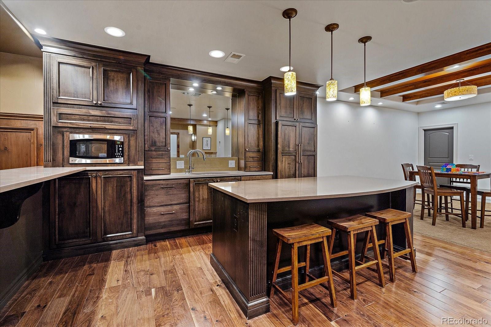 20132 East Shady Ridge Road Parker, CO 80134 - Photo 25 of 36 a kitchen with stainless steel appliances granite countertop wooden floors and wooden cabinets