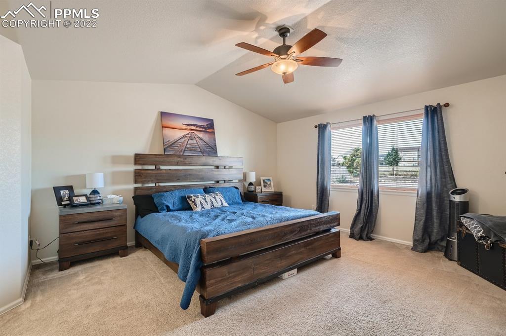 12118 Rio Secco Road Peyton, CO 80831 - Photo 12 of 23 a bedroom with a bed and a chandelier