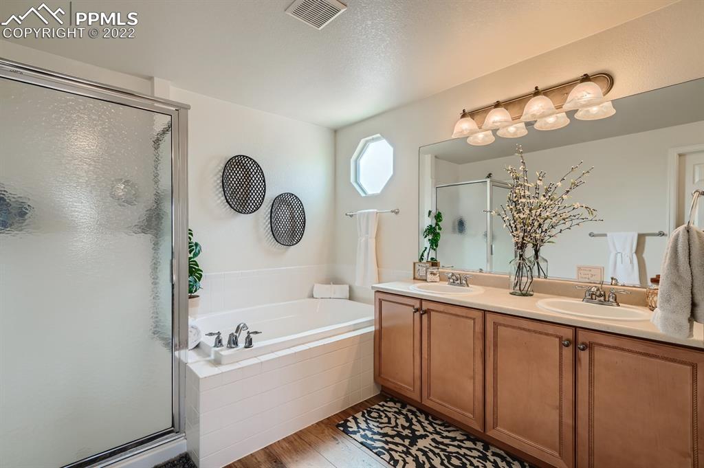 12118 Rio Secco Road Peyton, CO 80831 - Photo 13 of 23 a bathroom with a tub a sink and a mirror