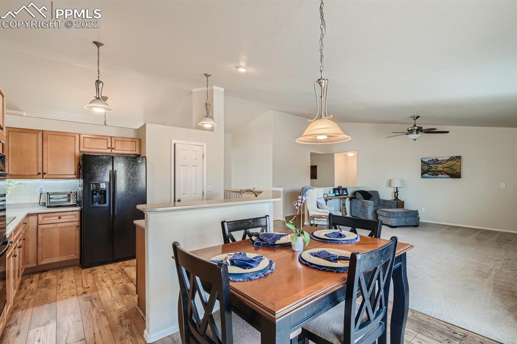 12118 Rio Secco Road Peyton, CO 80831 - Photo 9 of 23 a view of a dining room and livingroom with furniture wooden floor a chandelier