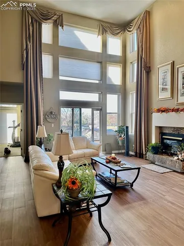 a living room with fireplace furniture and a large window
