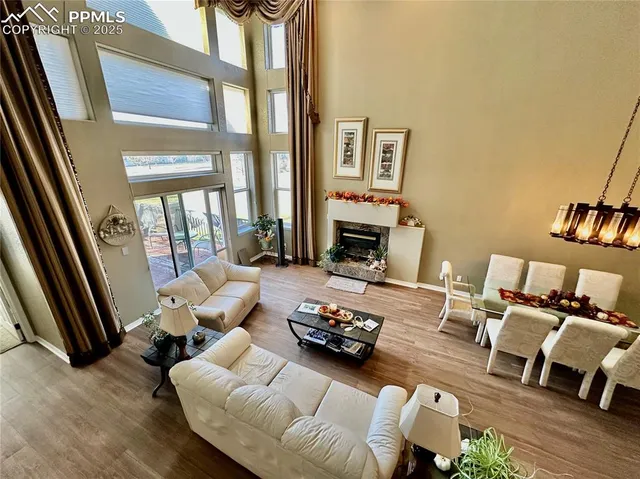 a living room with furniture floor to ceiling window and a fireplace