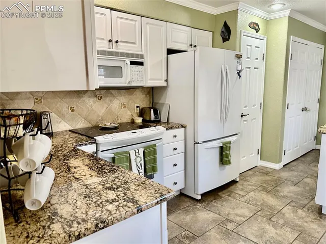a kitchen with white cabinets and white appliances