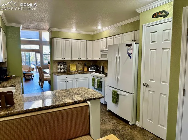 a kitchen with stainless steel appliances granite countertop a refrigerator a stove and a sink with wooden floor