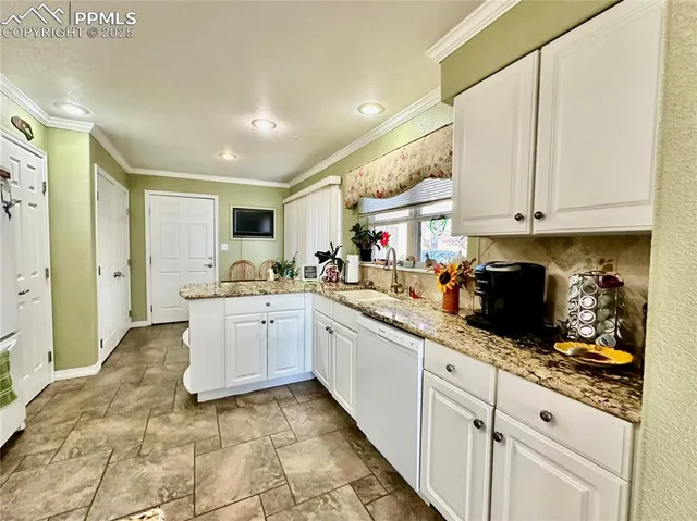 a kitchen with granite countertop white cabinets and white appliances