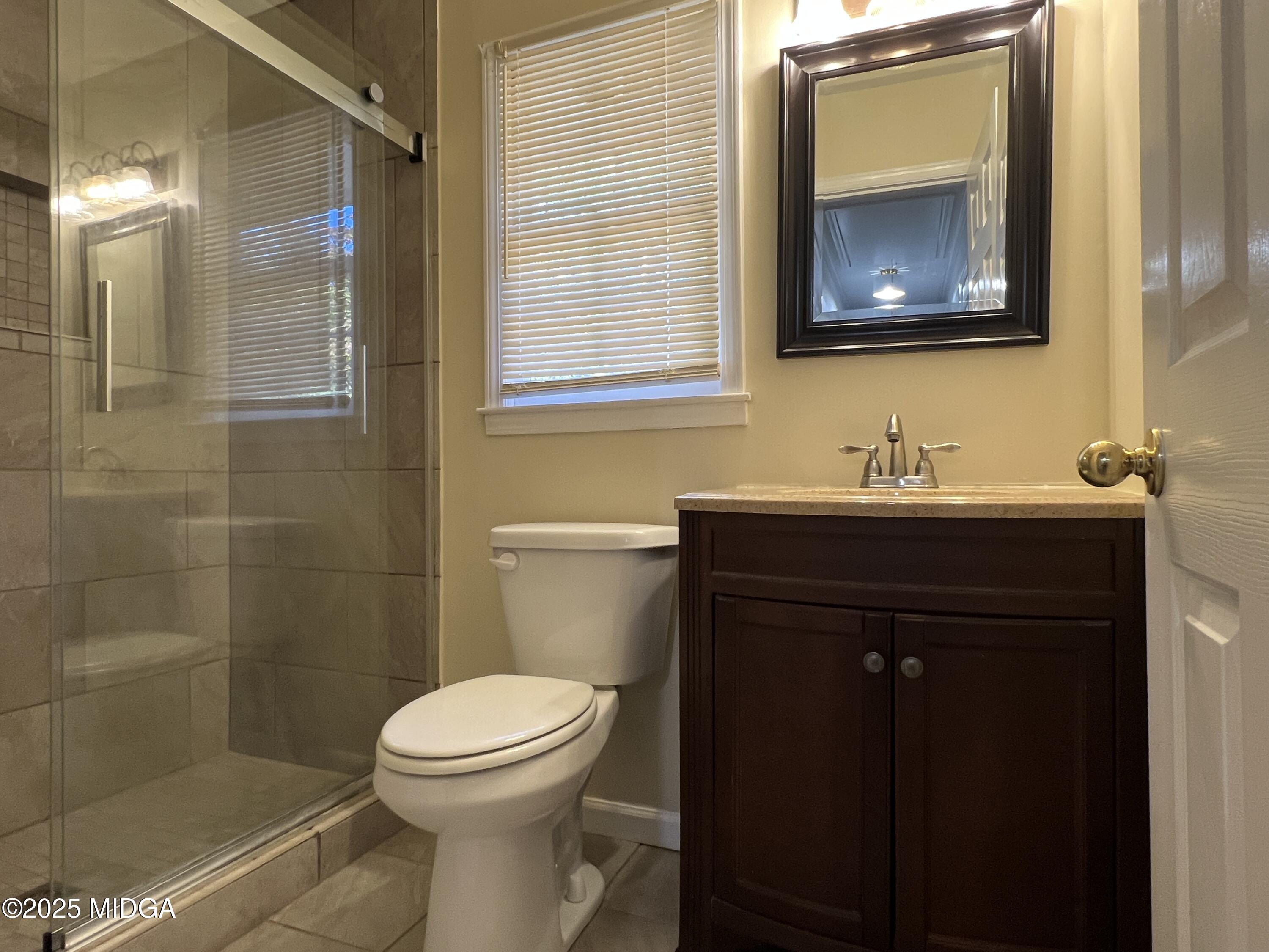 1149 Runnymede Lane Macon, GA 31220 - Photo 13 of 25 a bathroom with a toilet a sink and mirror