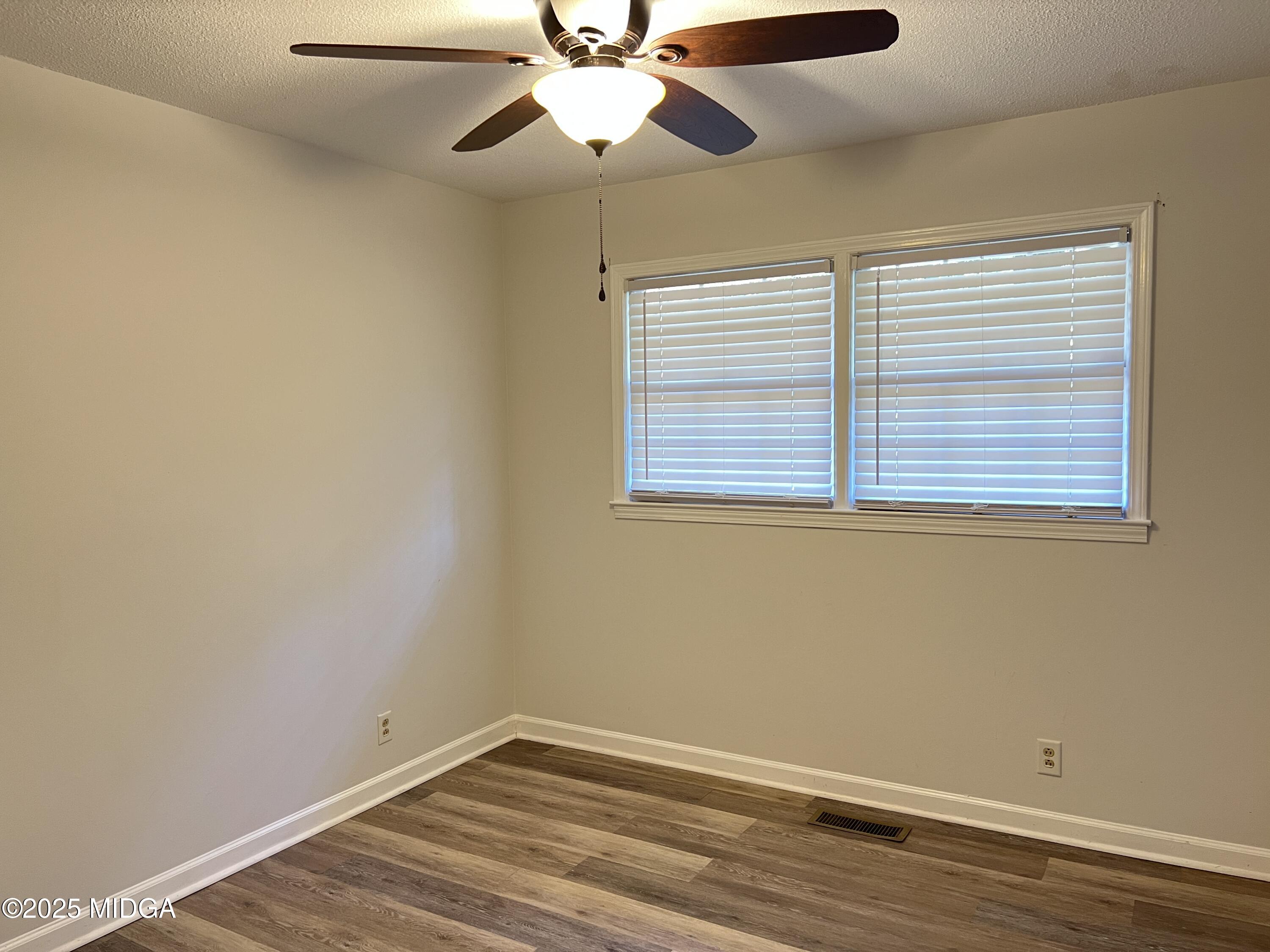 1149 Runnymede Lane Macon, GA 31220 - Photo 14 of 25 an empty room with wooden floor fan and windows