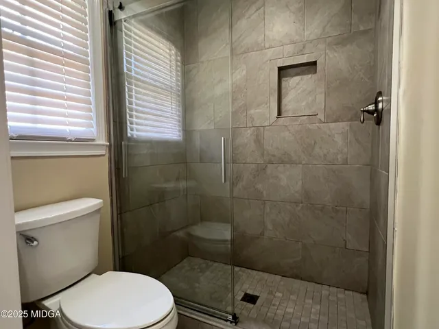 a bathroom with a toilet and a shower