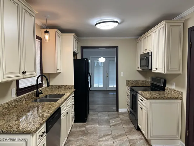 a kitchen with stainless steel appliances granite countertop a sink stove and refrigerator