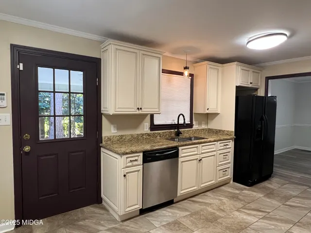 a kitchen with stainless steel appliances granite countertop a refrigerator and a sink