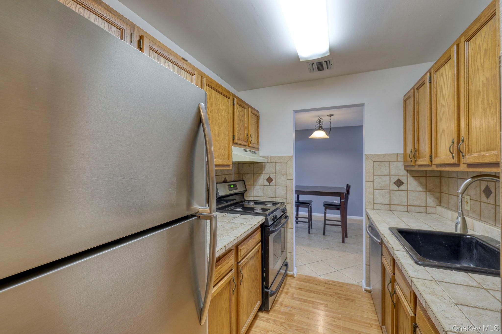 276 Temple Hill Road, Unit 2513 New Windsor, NY 12553 - Photo 2 of 15 a kitchen with granite countertop sink cabinets and stainless steel appliances