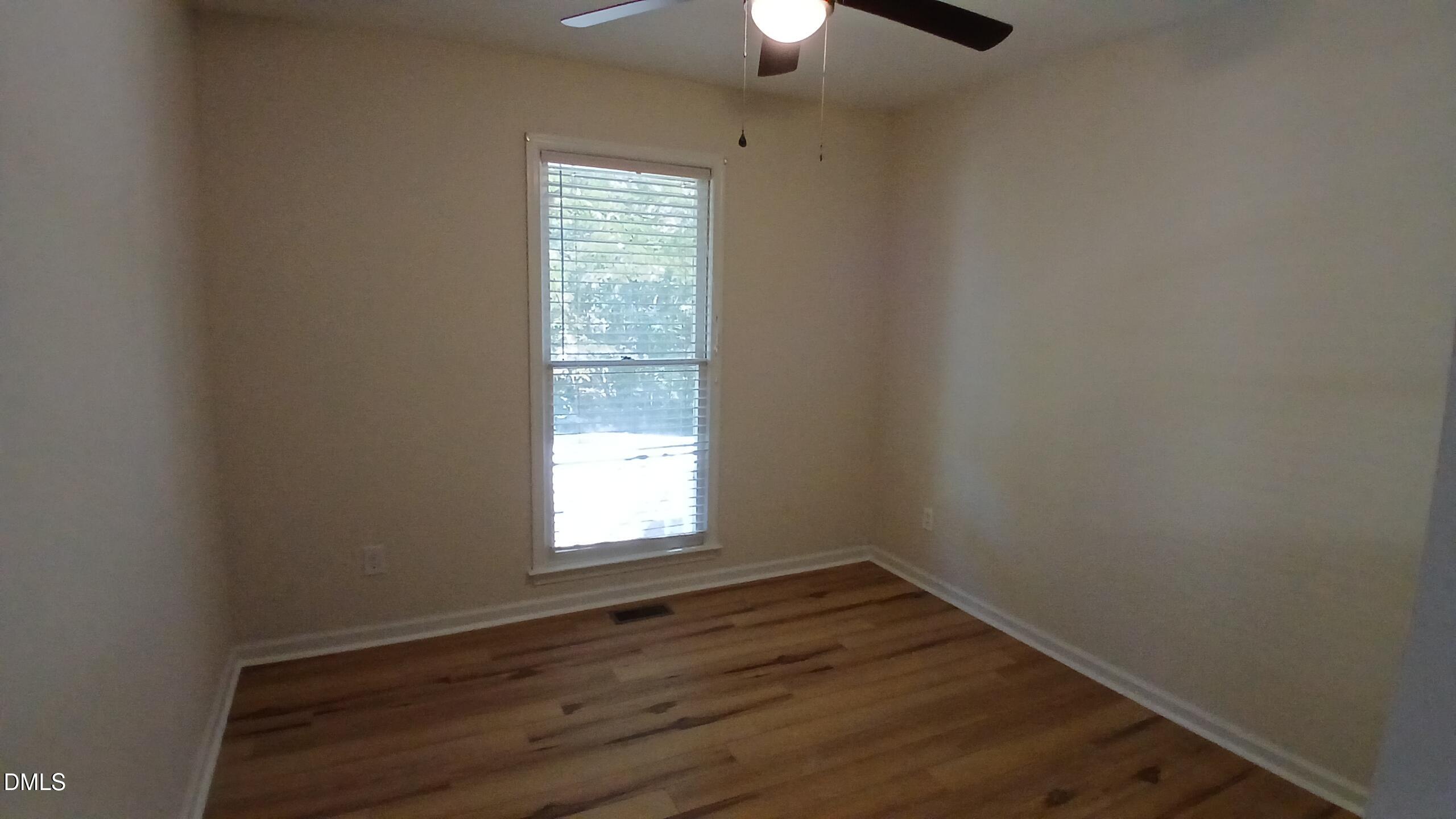 2224 Bufflehead Road Raleigh, NC 27616 - Photo 11 of 33 an empty room with wooden floor chandelier fan and window