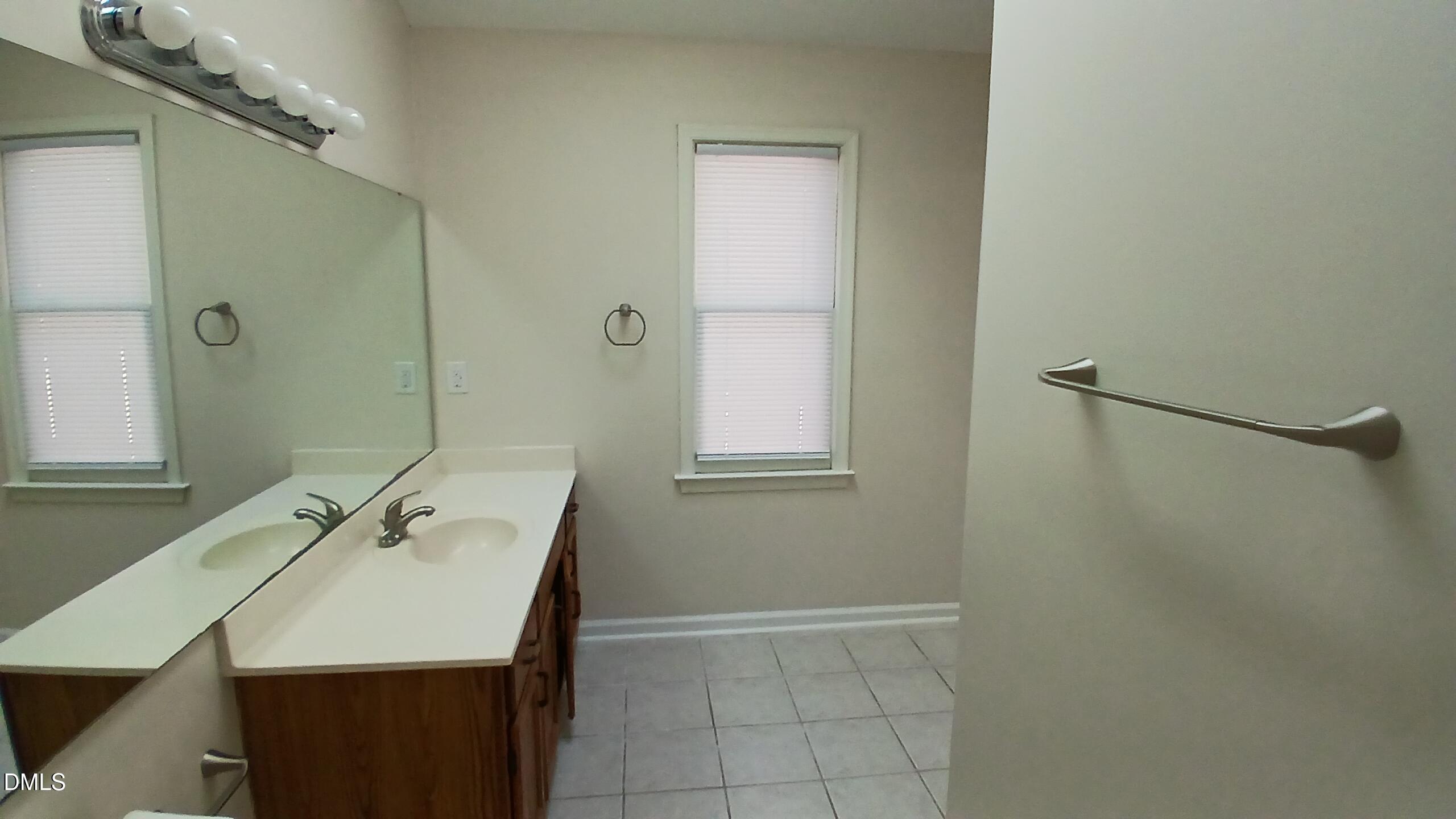 2224 Bufflehead Road Raleigh, NC 27616 - Photo 19 of 33 a bathroom with a sink a mirror and shower