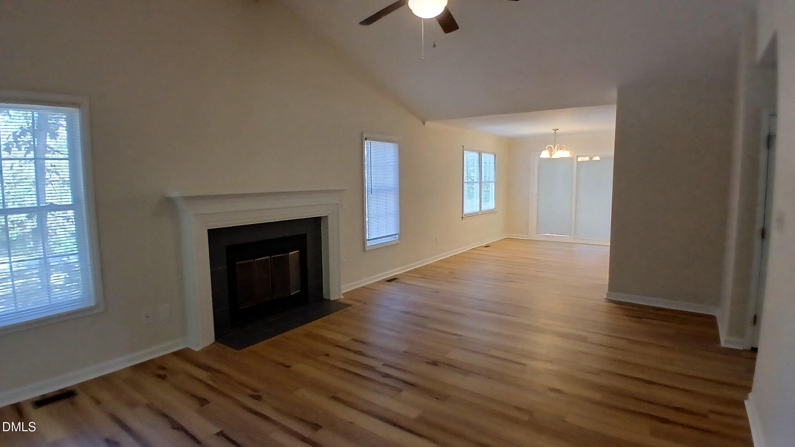 2224 Bufflehead Road Raleigh, NC 27616 - Photo 5 of 33 an empty room with wooden floor fireplace and windows