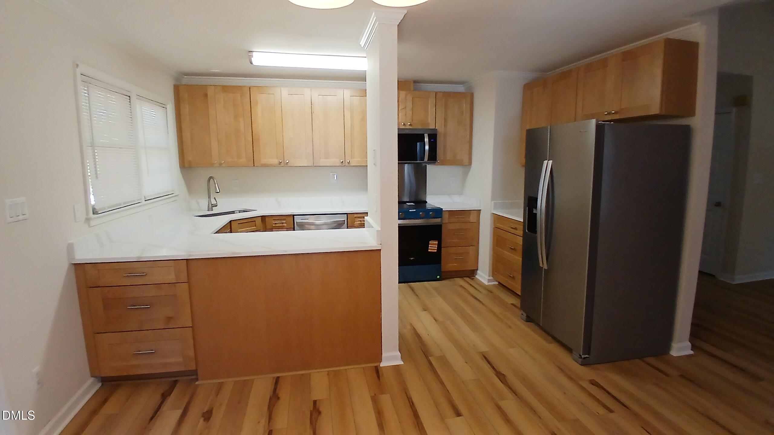 2224 Bufflehead Road Raleigh, NC 27616 - Photo 8 of 33 a kitchen with kitchen island wooden floors appliances and cabinets