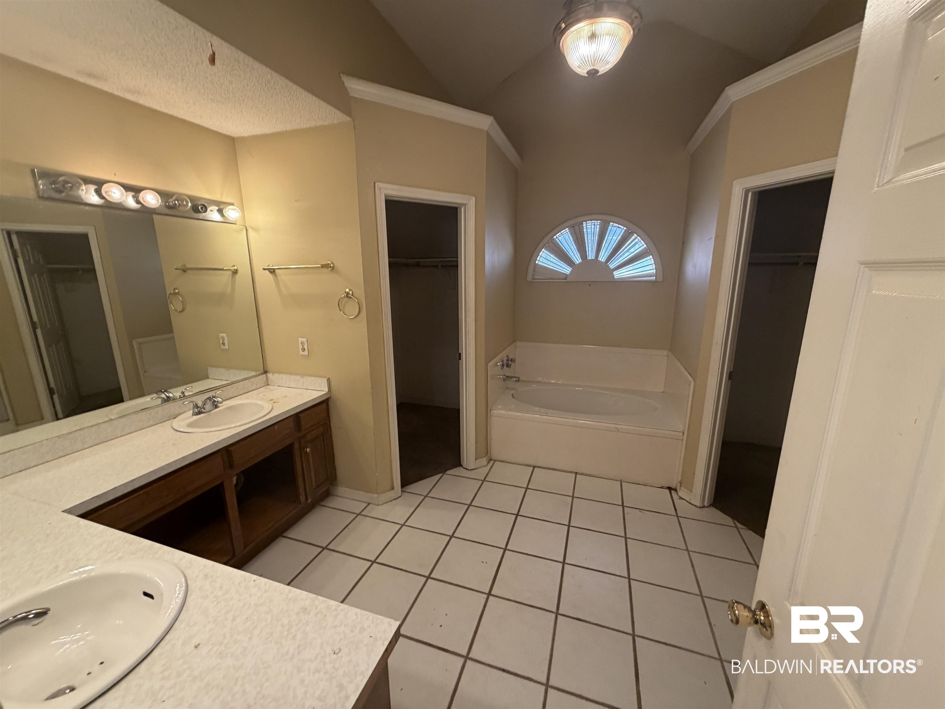 7067 Pinehill Road Daphne, AL 36526 - Photo 16 of 18 Full bathroom with a walk in closet, double vanity, lofted ceiling, light tile patterned floors, and a bath
