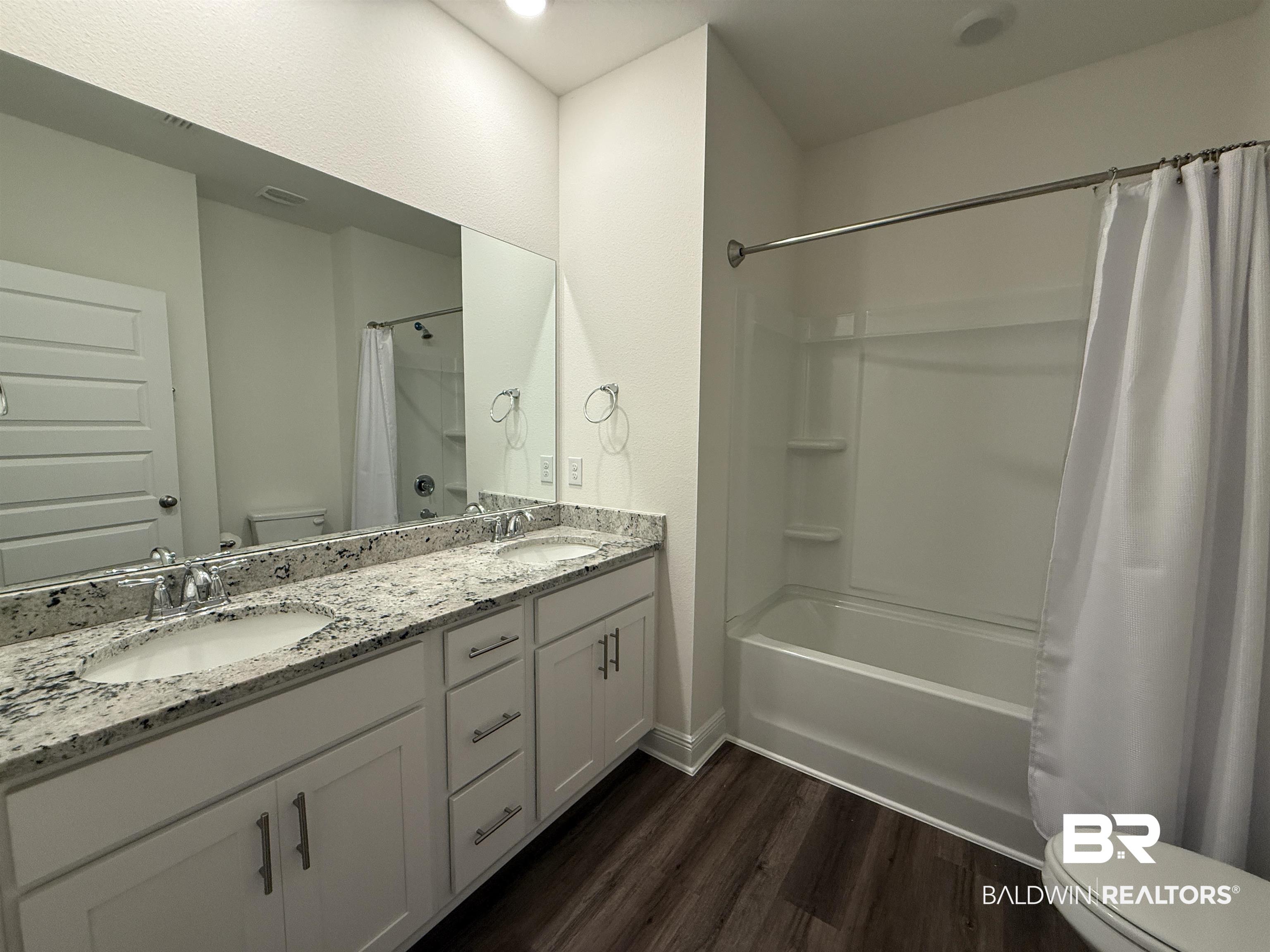 11442 Genuine Risk Circle Daphne, AL 36526 - Photo 19 of 21 Bathroom with double vanity, dark wood-style floors, and shower / bath combo