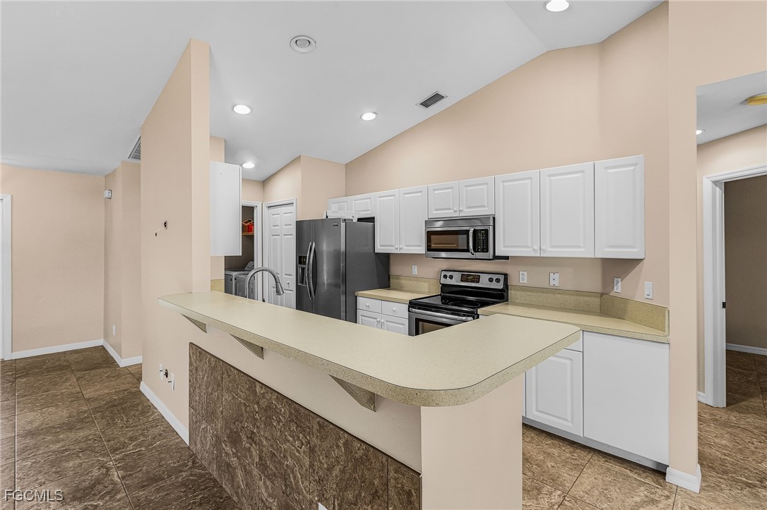 1644 Dawnview Street North Port, FL 34288 - Photo 19 of 32 a kitchen with white cabinets and stainless steel appliances