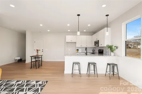 a large white kitchen with lots of furniture and appliances
