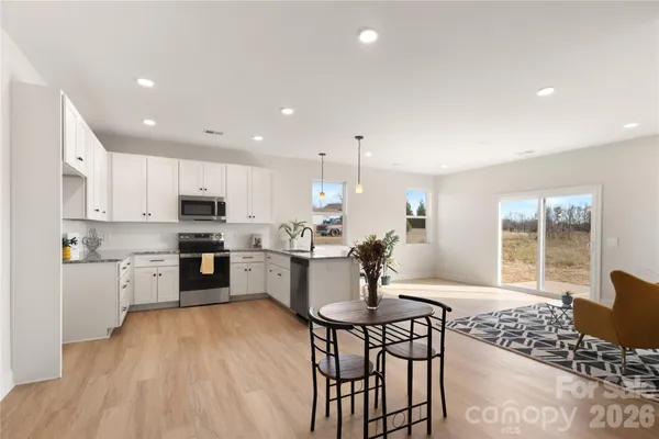 a kitchen with granite countertop white cabinets and stainless steel appliances
