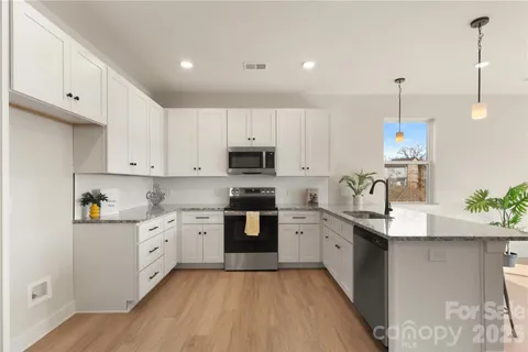 a kitchen with stainless steel appliances granite countertop a sink stove and refrigerator