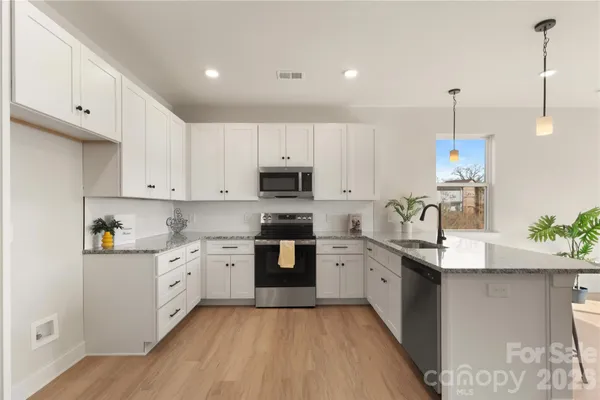 a kitchen with stainless steel appliances granite countertop a sink stove and refrigerator
