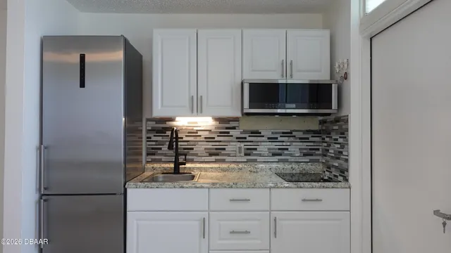 a kitchen with white cabinets and stainless steel appliances