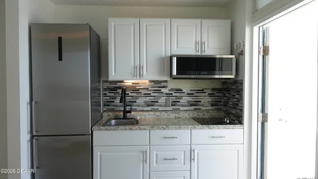 a kitchen with stainless steel appliances white cabinets and a refrigerator