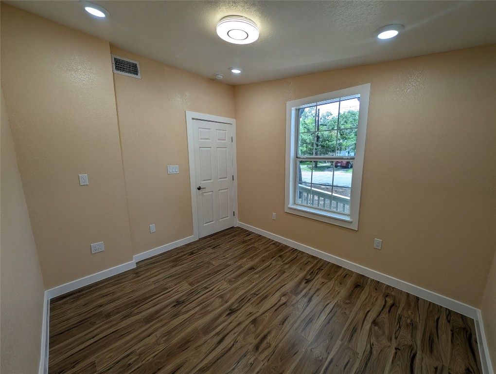 320 Laredo Street Lockhart, TX 78644 - Photo 16 of 27 Spare room featuring dark wood-style flooring and recessed lighting
