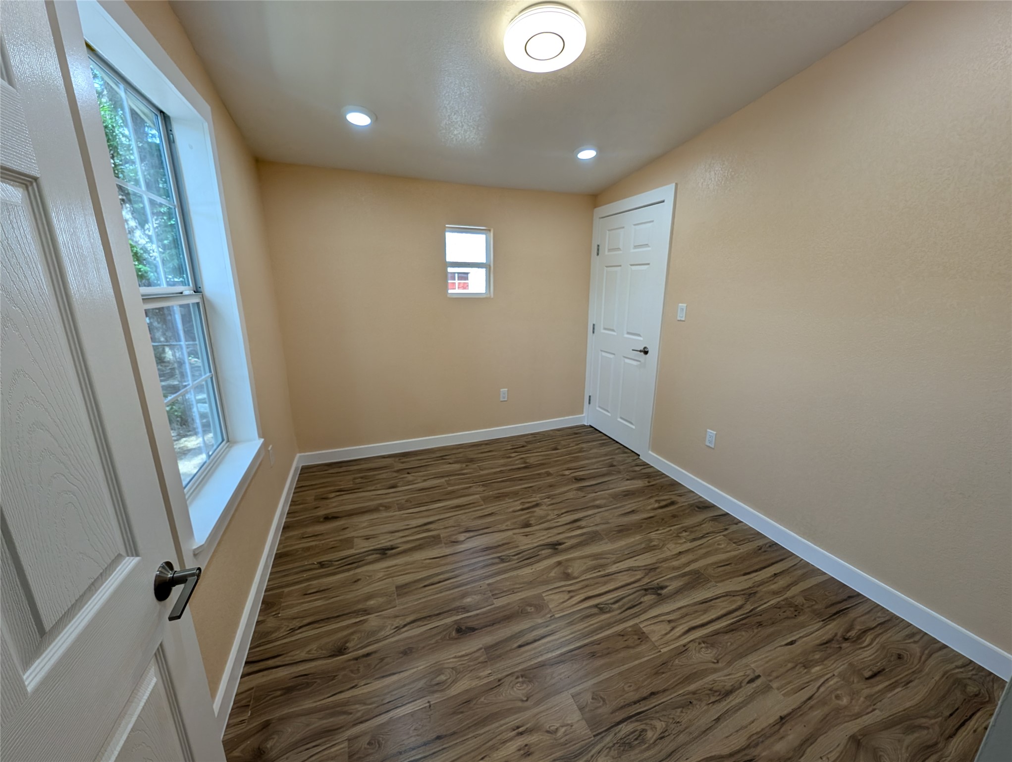 320 Laredo Street Lockhart, TX 78644 - Photo 18 of 27 a view of an empty room with wooden floor and a window