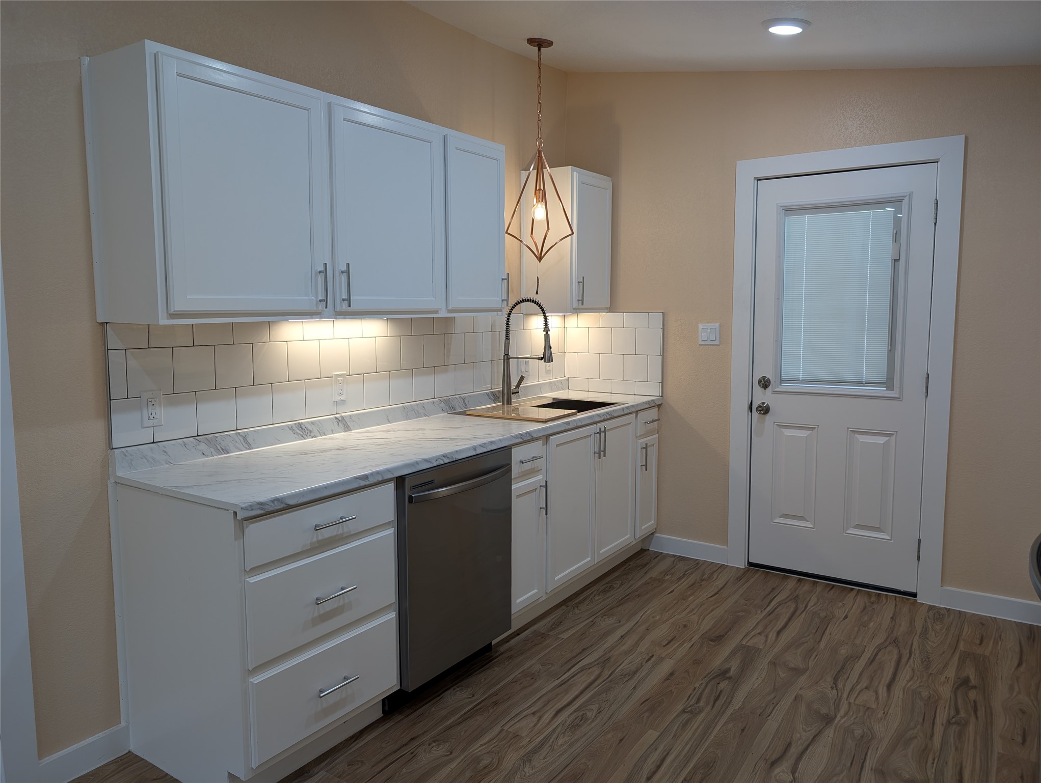 320 Laredo Street Lockhart, TX 78644 - Photo 5 of 27 a kitchen with a sink cabinets and wooden floor