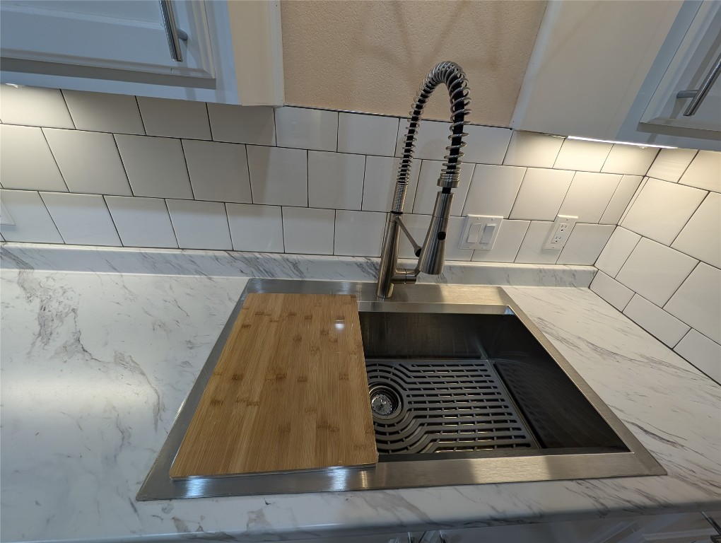 320 Laredo Street Lockhart, TX 78644 - Photo 7 of 27 Kitchen view of decorative backsplash and light stone countertops