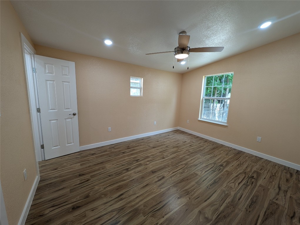 320 Laredo Street Lockhart, TX 78644 - Photo 9 of 27 Empty room featuring recessed lighting, dark wood-type flooring, plenty of natural light, a textured ceiling, and ceiling fan